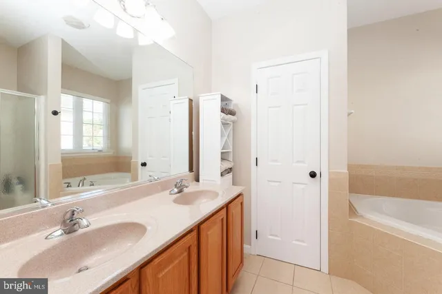 a bathroom with a granite countertop sink mirror and a bathtub