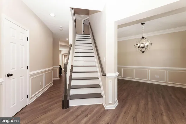 a view of a hallway with wooden floor and stairs