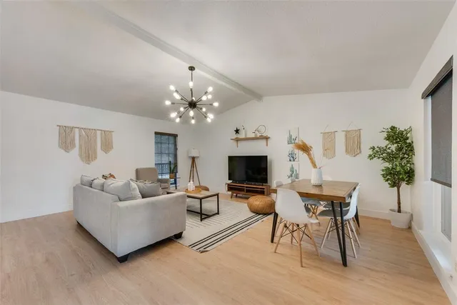a living room with furniture a chandelier and a flat screen tv