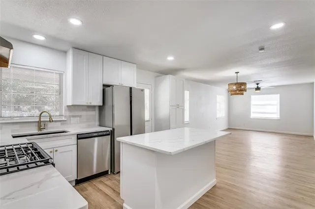 a kitchen with stainless steel appliances a refrigerator sink and cabinets