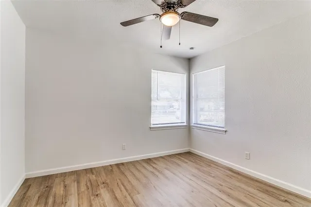 an empty room with a window and wooden floor