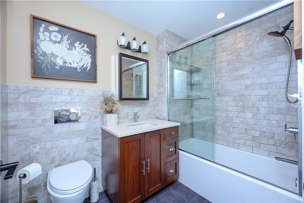 7819 Bay Parkway, Unit PH Brooklyn, NY 11214 - Photo 12 of 28 a bathroom with a sink a toilet and shower