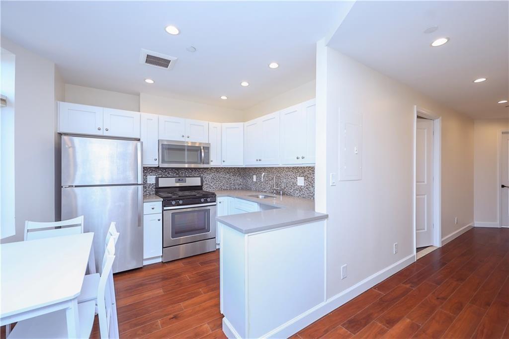 7819 Bay Parkway, Unit PH Brooklyn, NY 11214 - Photo 9 of 28 a kitchen with stainless steel appliances granite countertop a refrigerator a stove a sink and a microwave