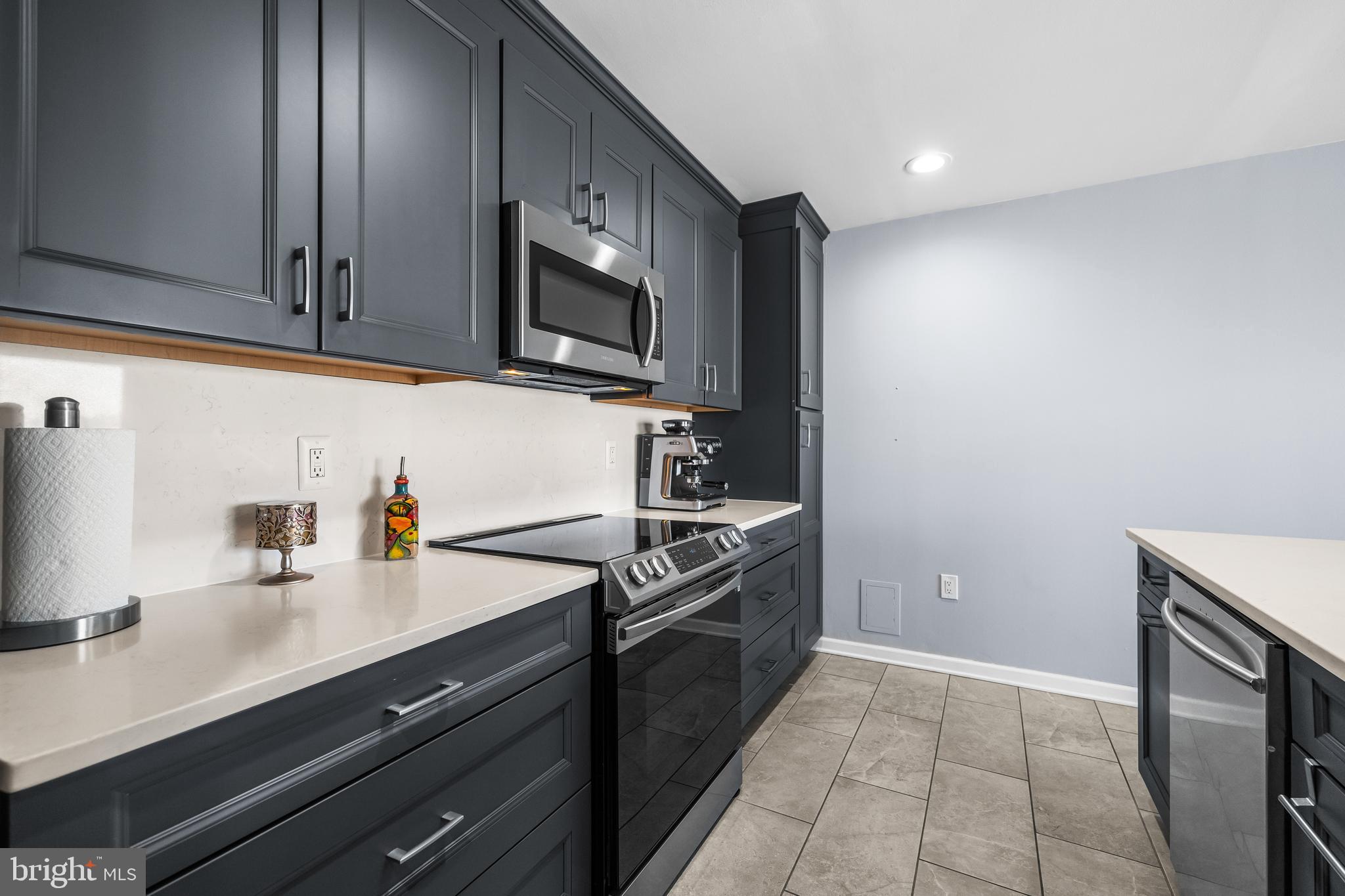 2702 Lighthouse Point East, Unit 720 Baltimore, MD 21224 - Photo 11 of 37 a kitchen with stainless steel appliances granite countertop a sink stove and microwave