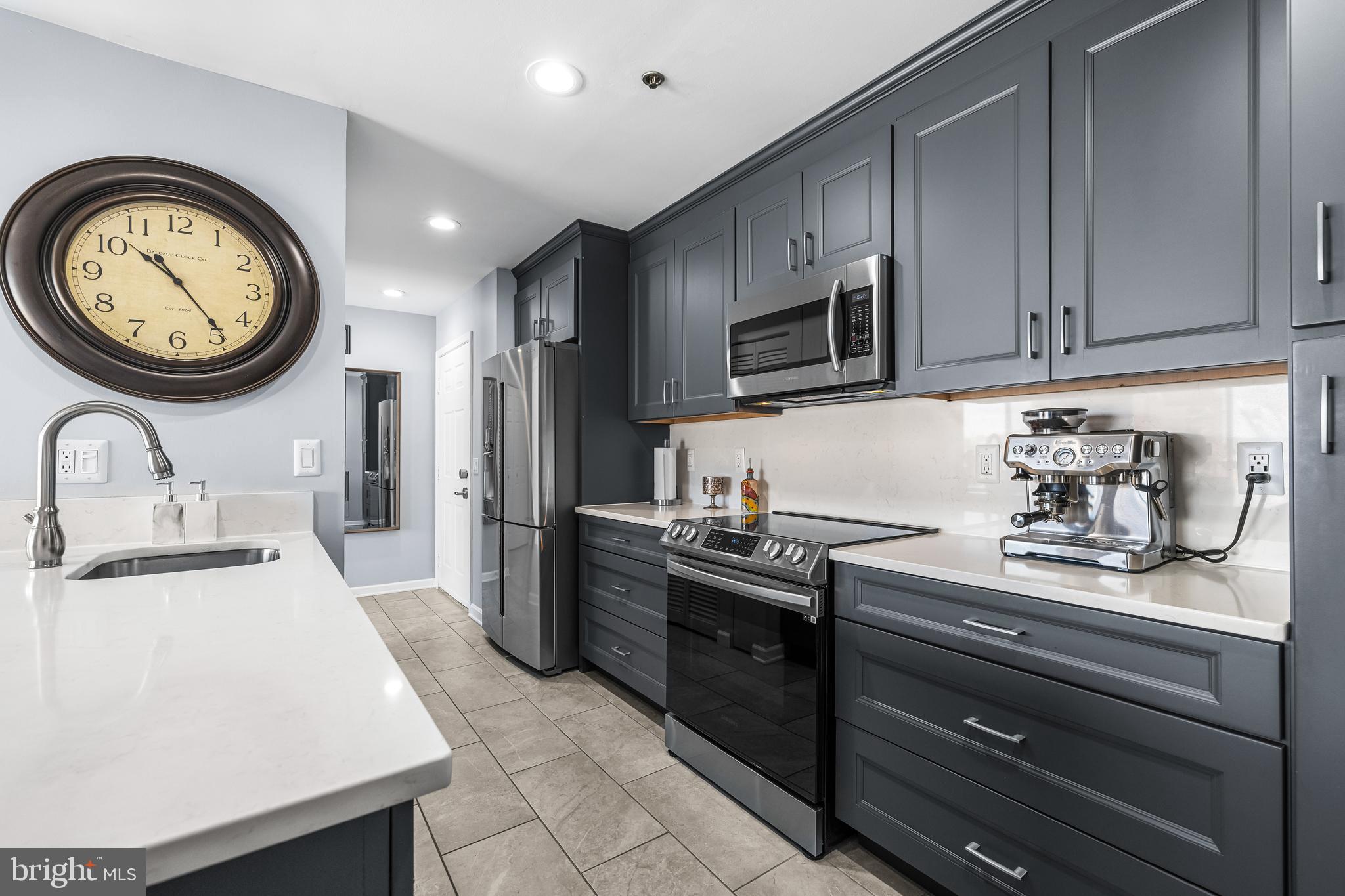 2702 Lighthouse Point East, Unit 720 Baltimore, MD 21224 - Photo 12 of 37 a kitchen with stainless steel appliances granite countertop a sink a stove and a refrigerator