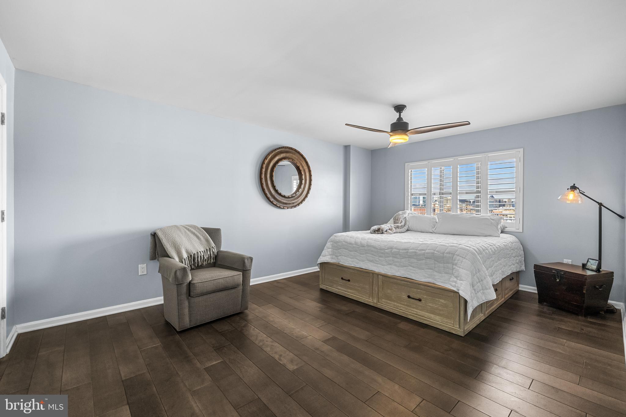 2702 Lighthouse Point East, Unit 720 Baltimore, MD 21224 - Photo 14 of 37 a spacious bedroom with a bed and a chandelier