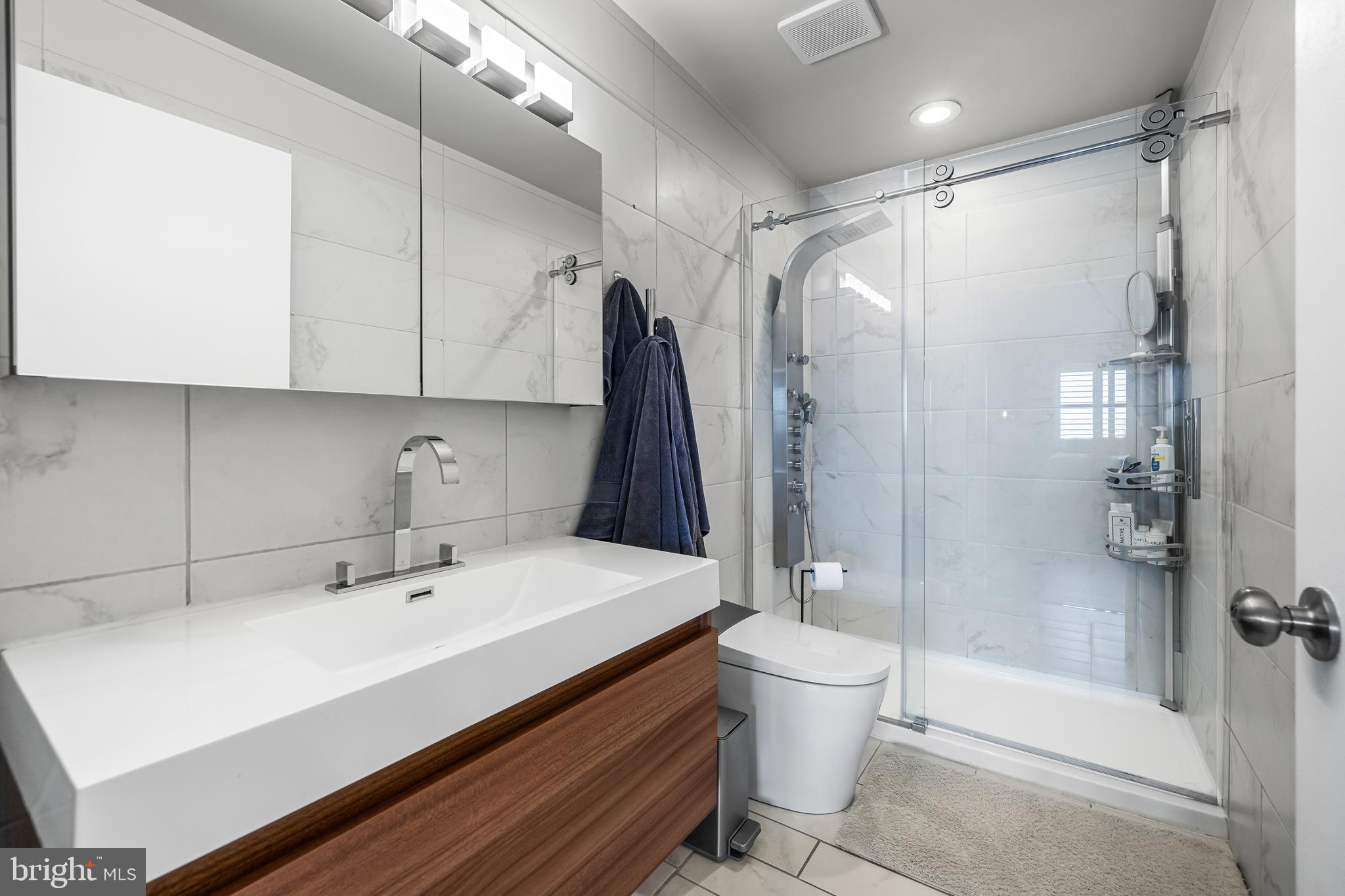2702 Lighthouse Point East, Unit 720 Baltimore, MD 21224 - Photo 18 of 37 a bathroom with a sink toilet and shower glass cabinet