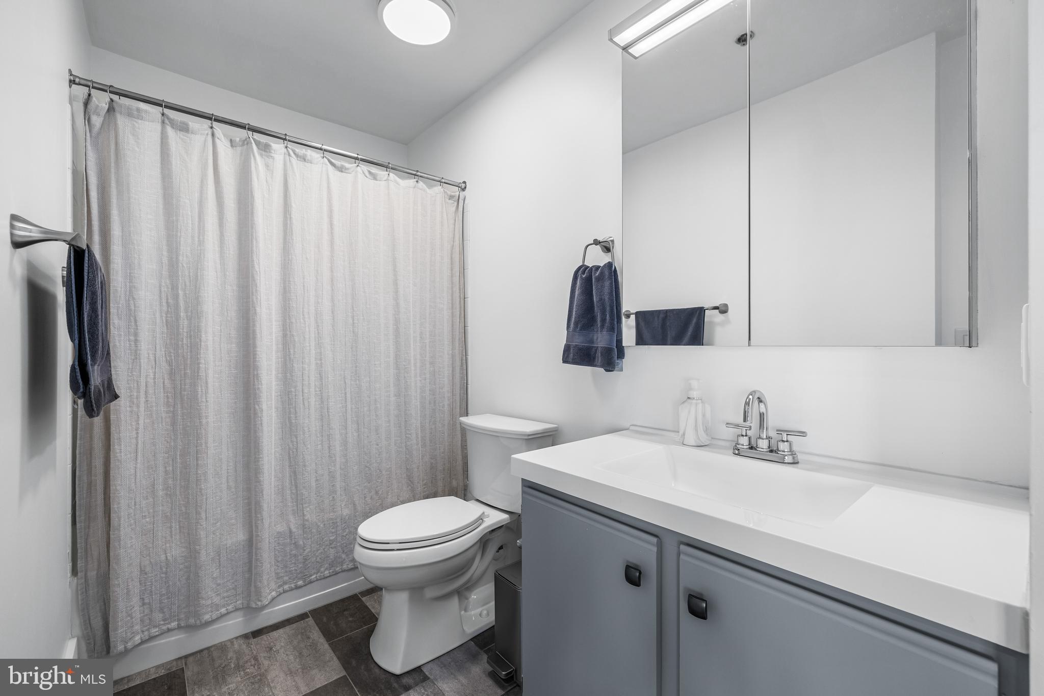 2702 Lighthouse Point East, Unit 720 Baltimore, MD 21224 - Photo 22 of 37 a bathroom with a sink a toilet and shower