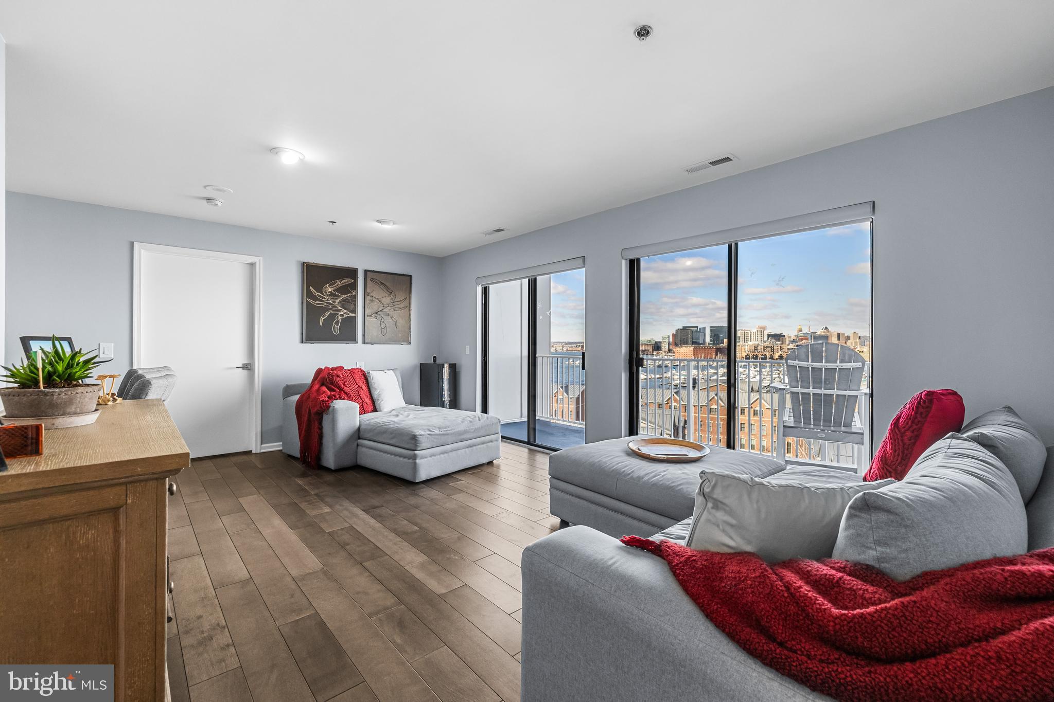 2702 Lighthouse Point East, Unit 720 Baltimore, MD 21224 - Photo 6 of 37 a living room with furniture and a large window