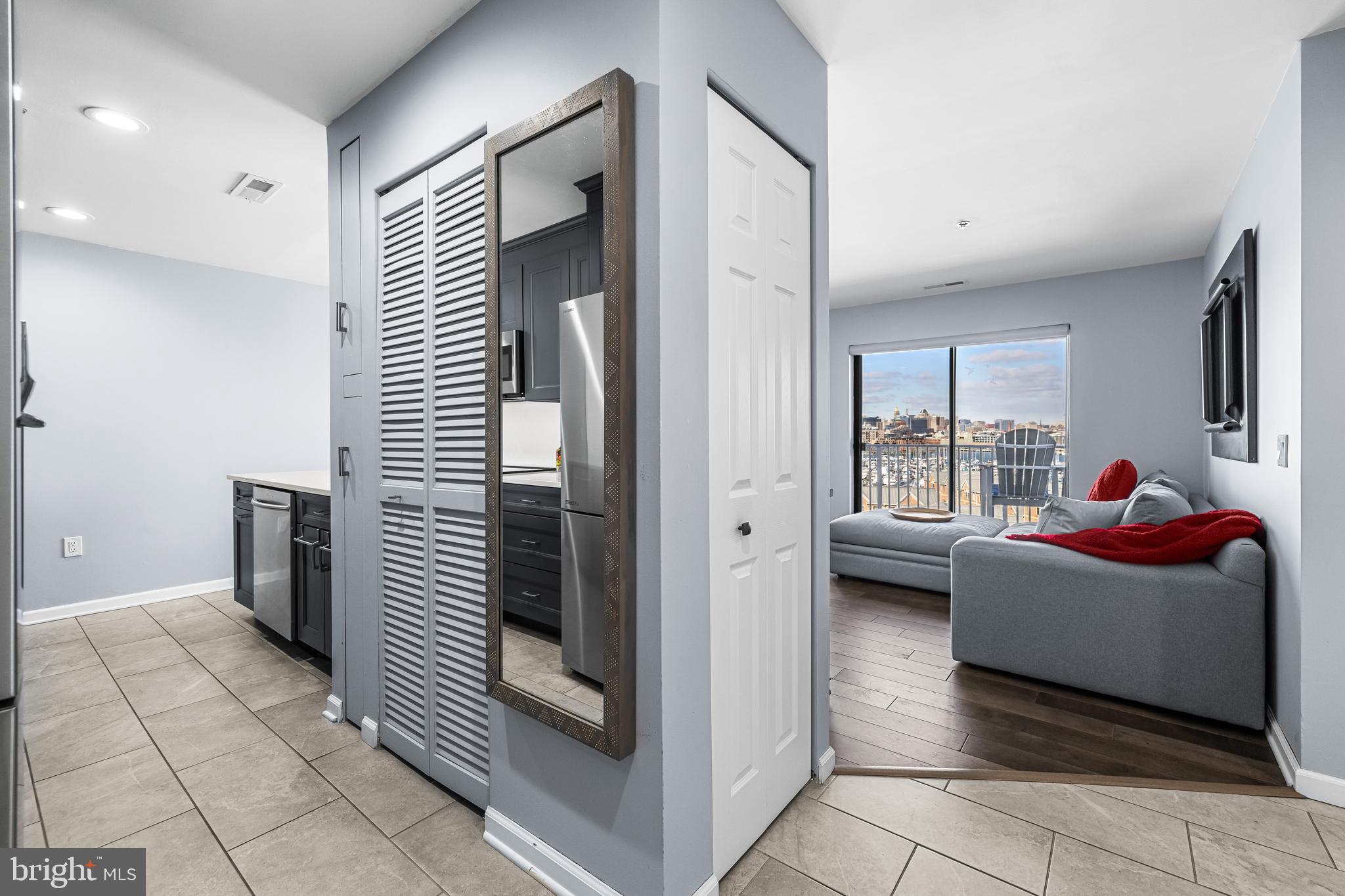 2702 Lighthouse Point East, Unit 720 Baltimore, MD 21224 - Photo 7 of 37 a living room with furniture and a window