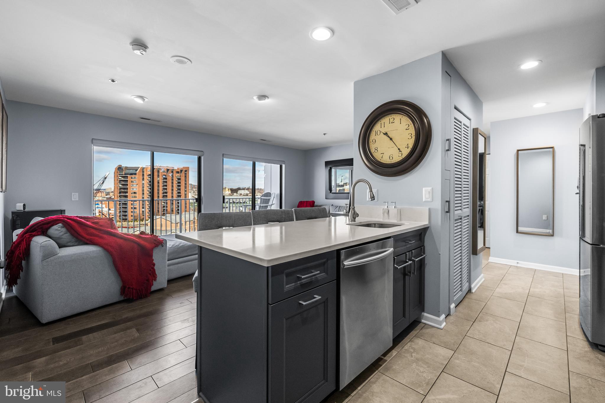 2702 Lighthouse Point East, Unit 720 Baltimore, MD 21224 - Photo 8 of 37 a living room with a bed furniture and a large window