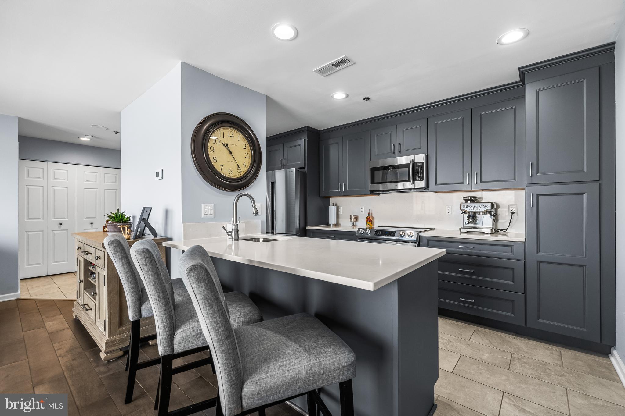2702 Lighthouse Point East, Unit 720 Baltimore, MD 21224 - Photo 10 of 37 a kitchen with a table chairs and a refrigerator
