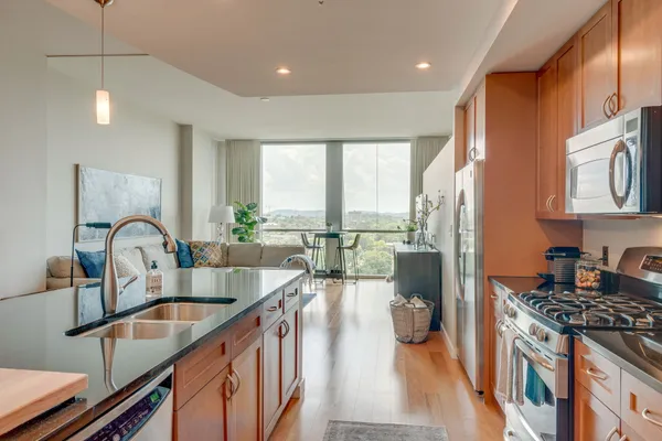 a kitchen with kitchen island a large counter top space a sink stainless steel appliances and cabinets