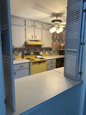 a kitchen with a stove a sink and cabinets