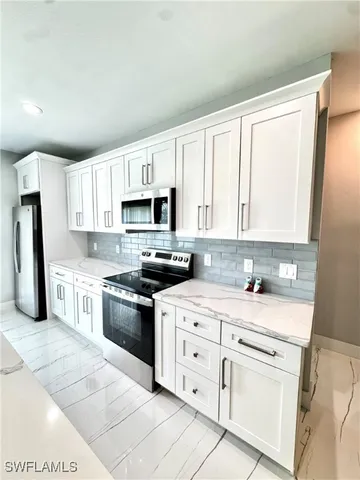 a kitchen with cabinets appliances a sink and a window