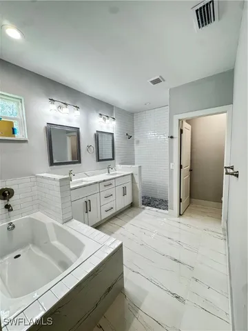 a spacious bathroom with a sink a mirror and a bathtub