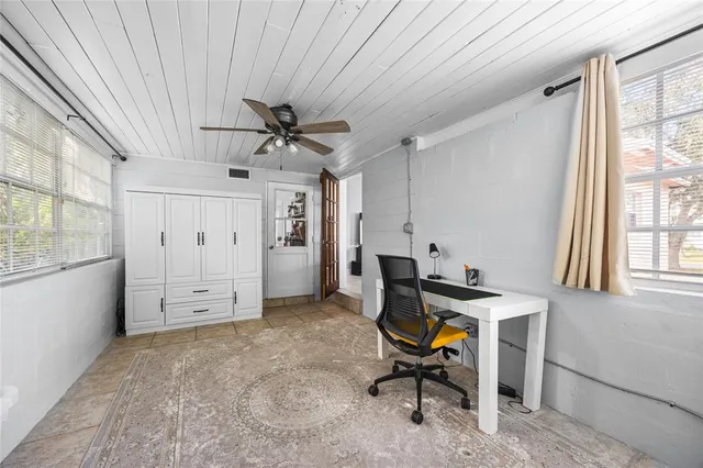 a view of a workspace with furniture and a window