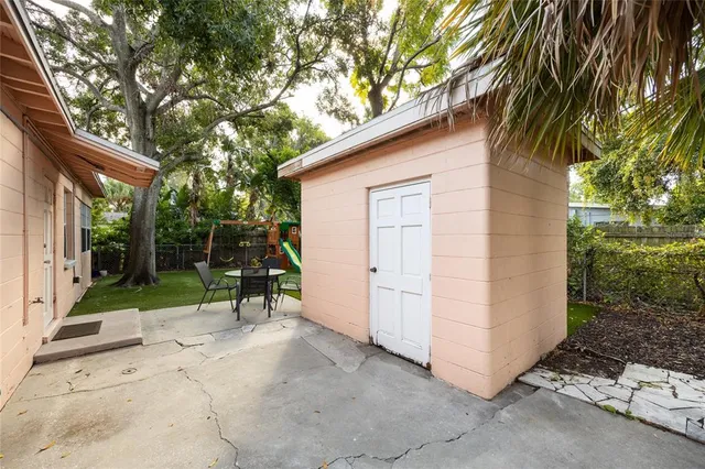 a view of backyard with a barn and a large tree