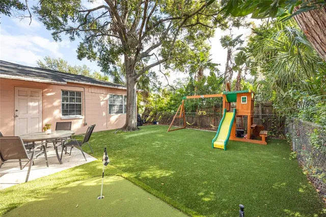 a view of a house with a backyard and a slide