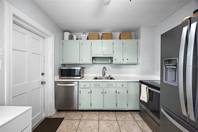a kitchen with white cabinets stainless steel appliances and a sink