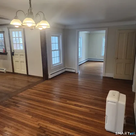 a view of a livingroom with wooden floor and chandelier