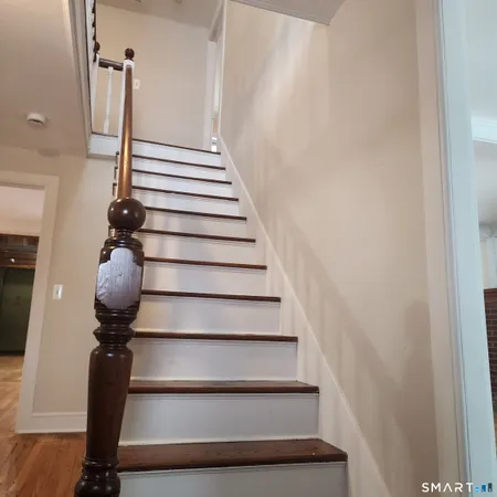 a view of entryway and hall with wooden floor