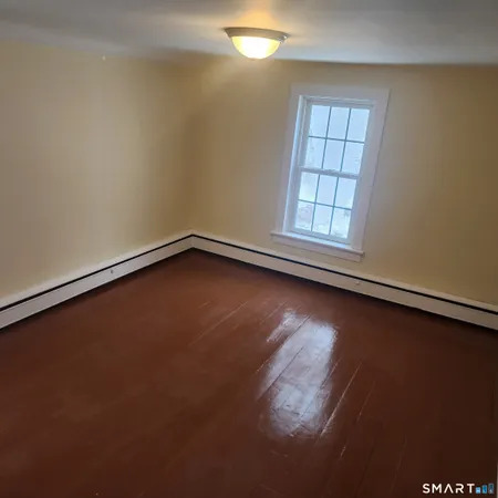 an empty room with wooden floor and windows in it