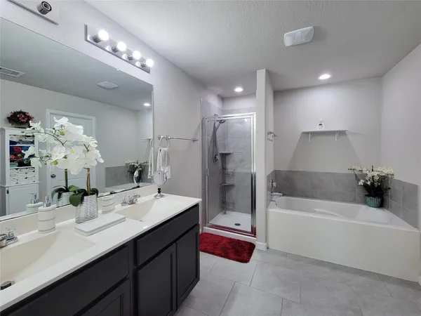 a bathroom with a tub a double vanity sink double vanity and shower