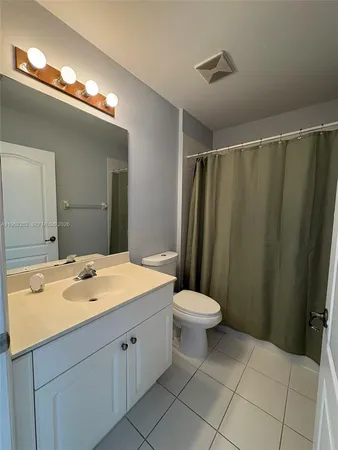 a bathroom with a sink a toilet a mirror and shower