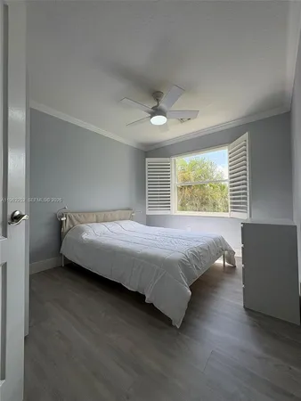 a bed sitting in a spacious bedroom next to a window