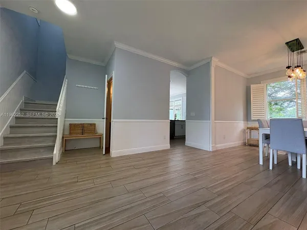 a view of empty room with wooden floor and stairs