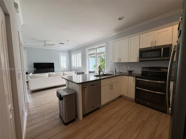 a kitchen with stainless steel appliances a stove sink microwave and cabinets