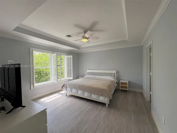 a bedroom with a bed tv and a window