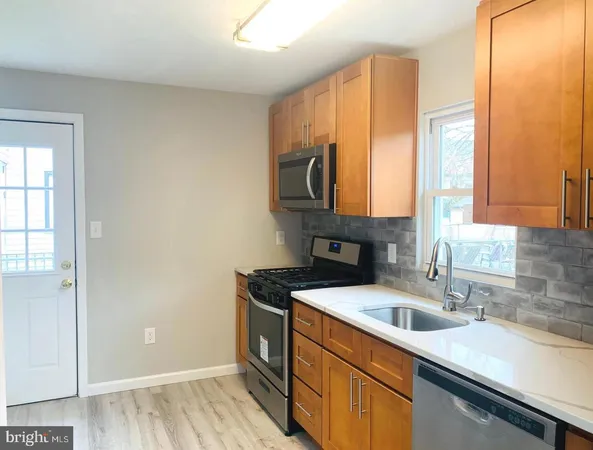 a kitchen with stainless steel appliances granite countertop a sink a stove and a refrigerator