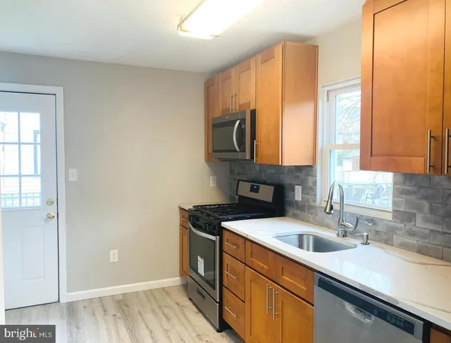 a kitchen with stainless steel appliances granite countertop a sink a stove and a refrigerator