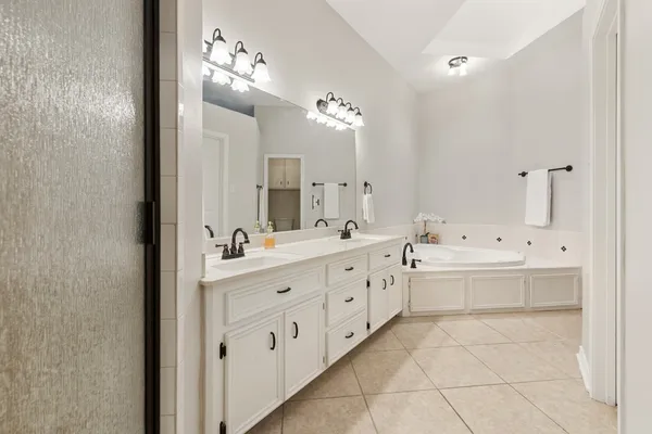 a spacious bathroom with a double vanity sink mirror and bathtub