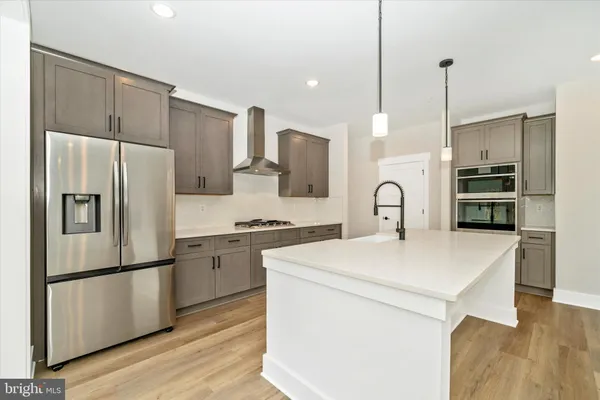 a kitchen with stainless steel appliances a refrigerator sink and stove