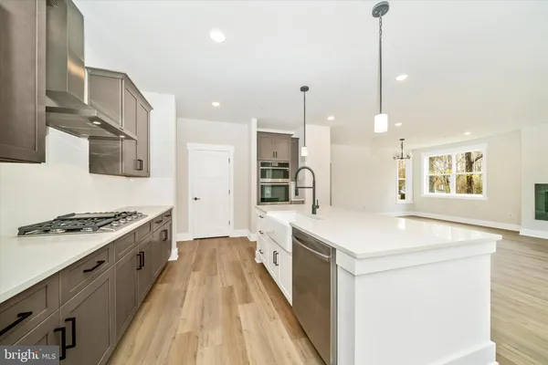 a large kitchen with kitchen island a stove a sink a dining table and chairs