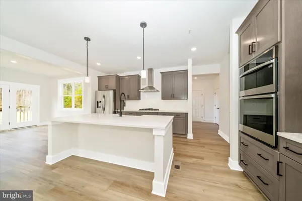 a kitchen with stainless steel appliances granite countertop a stove a sink and a wooden floor