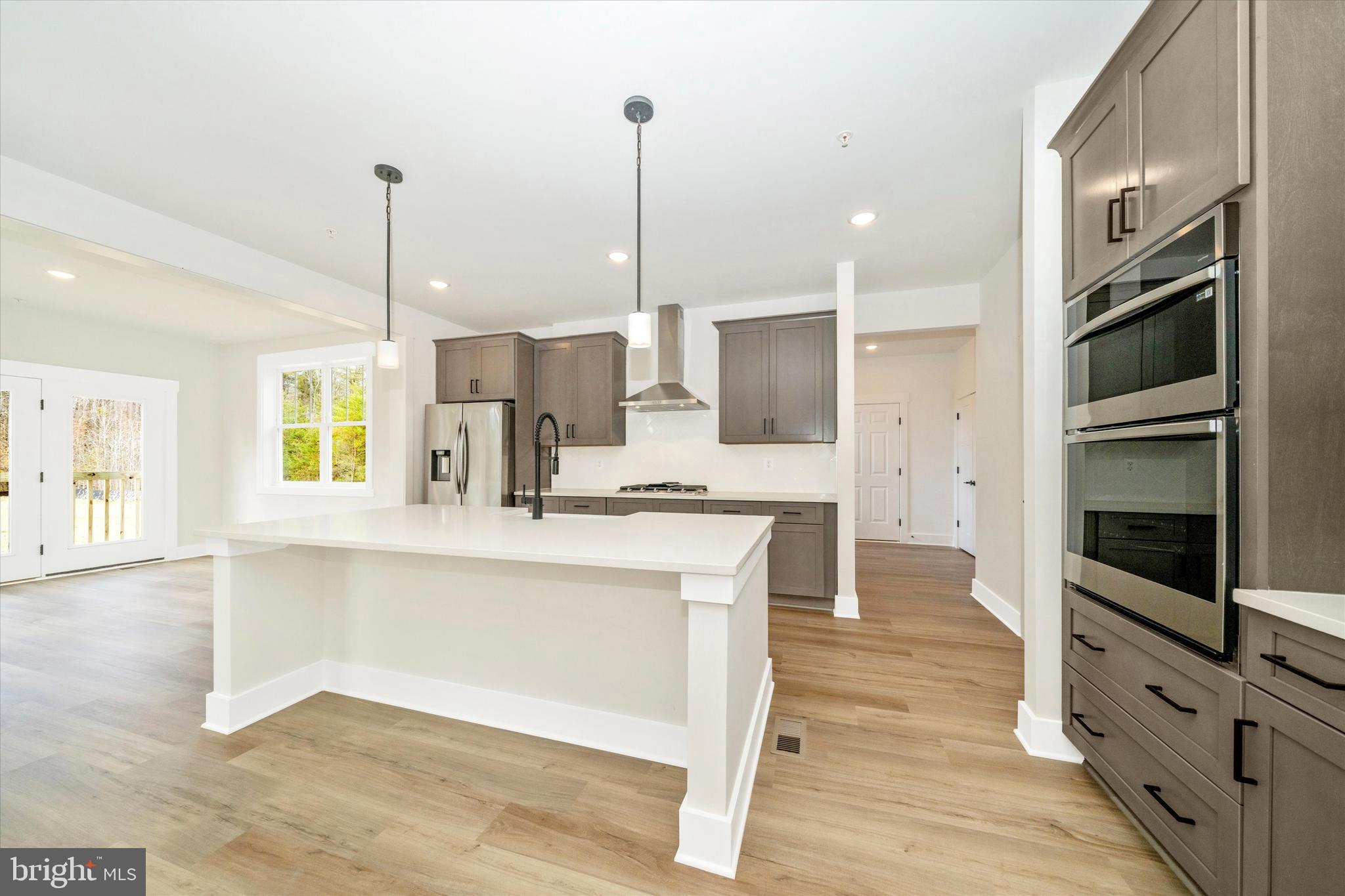 1154 Mt Zion Marlboro Road Lothian, MD 20711 - Photo 19 of 66 a kitchen with stainless steel appliances kitchen island granite countertop a stove a sink and a wooden floor