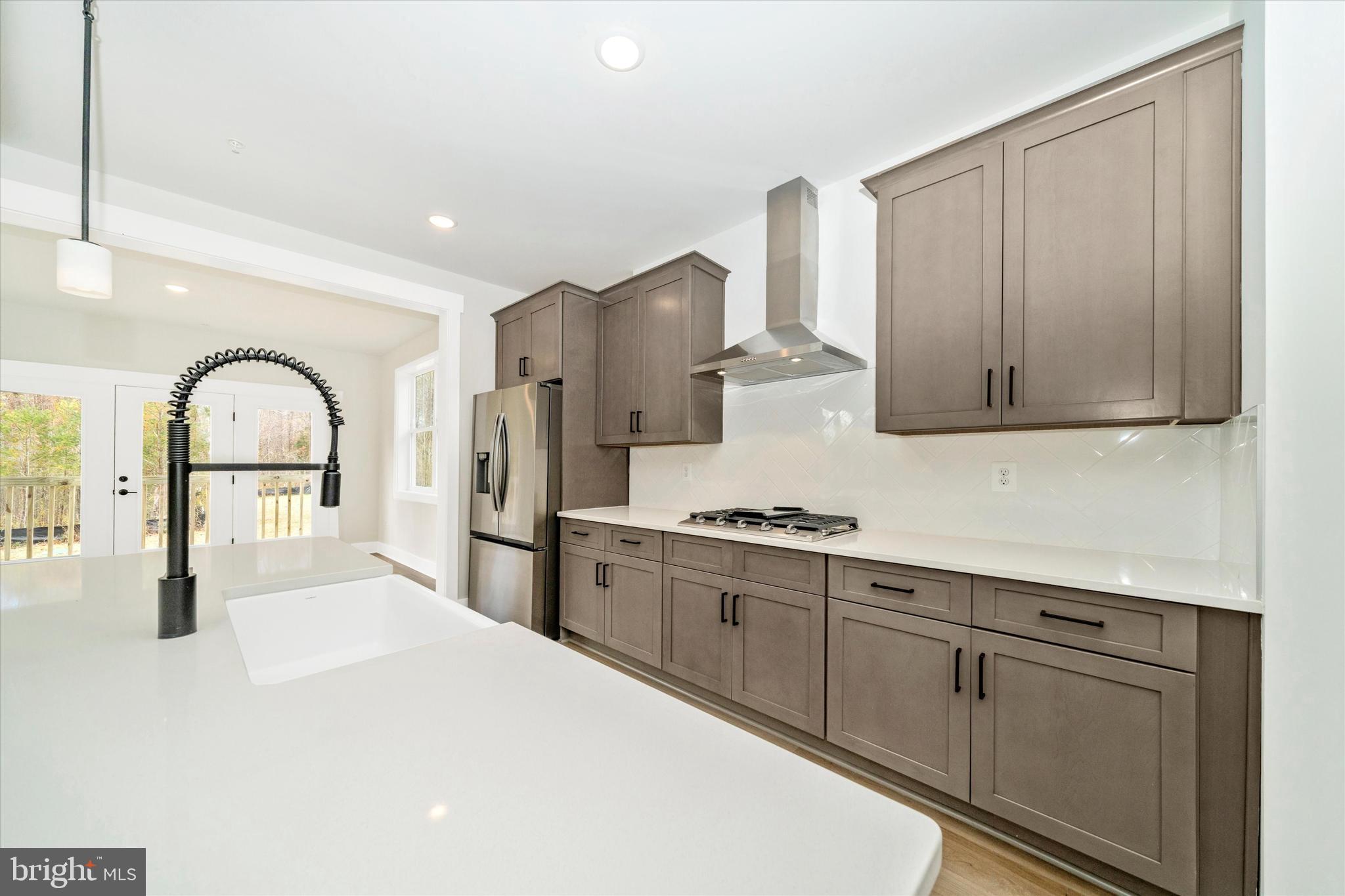 1154 Mt Zion Marlboro Road Lothian, MD 20711 - Photo 20 of 66 a kitchen with stainless steel appliances granite countertop a stove a sink dishwasher and a refrigerator with wooden floor