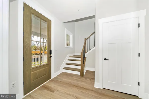 a view of a hallway with wooden floor and entryway