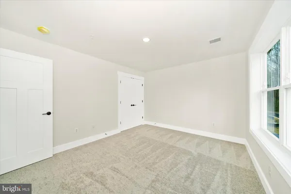 a view of a bedroom with wooden floor and furniture