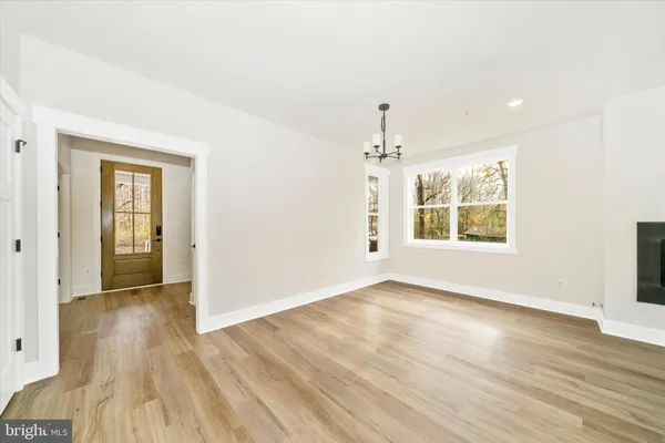 an empty room with wooden floor cabinet and windows