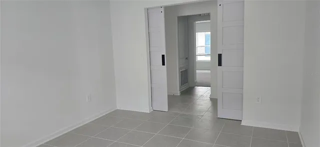 a view of an empty room and a bathroom with a sink
