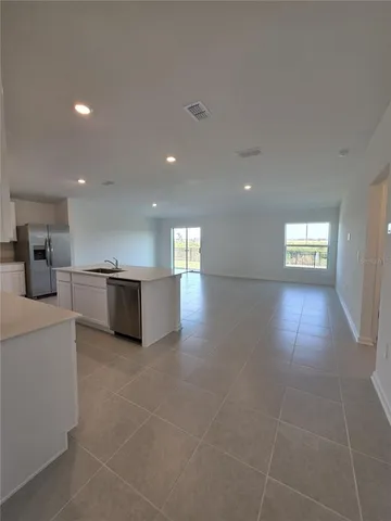 a view of empty room with wooden floor and windows