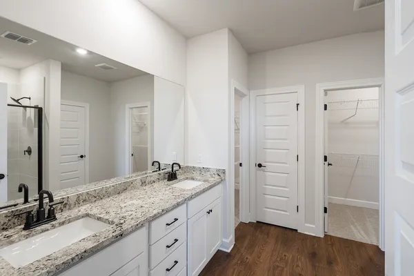 a spacious bathroom with a granite countertop sink and a mirror