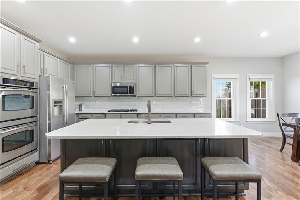 4415 Brampton Way Cumming, GA 30041 - Photo 18 of 59 a kitchen with stainless steel appliances granite countertop a table chairs microwave and sink