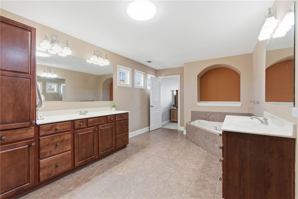 4415 Brampton Way Cumming, GA 30041 - Photo 36 of 59 a spacious bathroom with a double vanity sink and a mirror