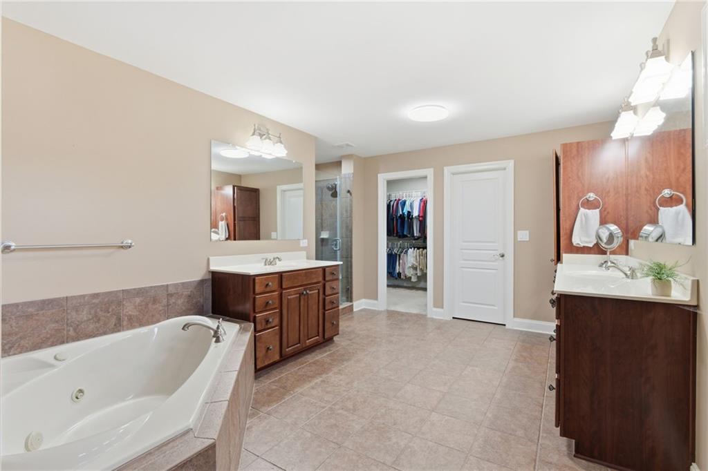 4415 Brampton Way Cumming, GA 30041 - Photo 37 of 59 a bathroom with a tub a sink and mirror
